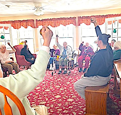 Kelsey leading an exercise group with residents seated in a circle